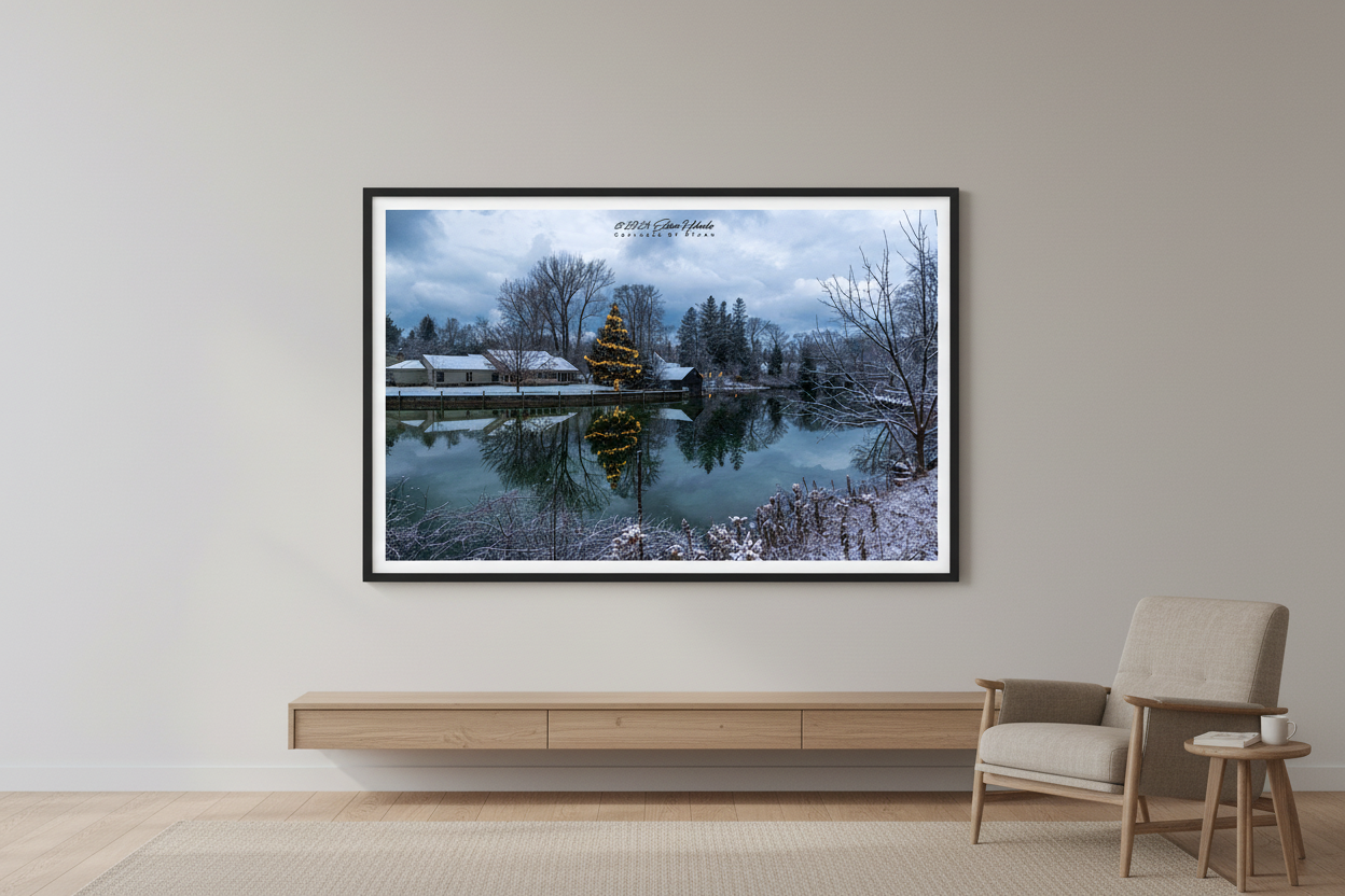 Large fine art print of illuminated Christmas tree reflected in the glassy Leland River with fresh snow on historic original dock wall and buildings in Leland Michigan December 11 2022 displayed in modern living room