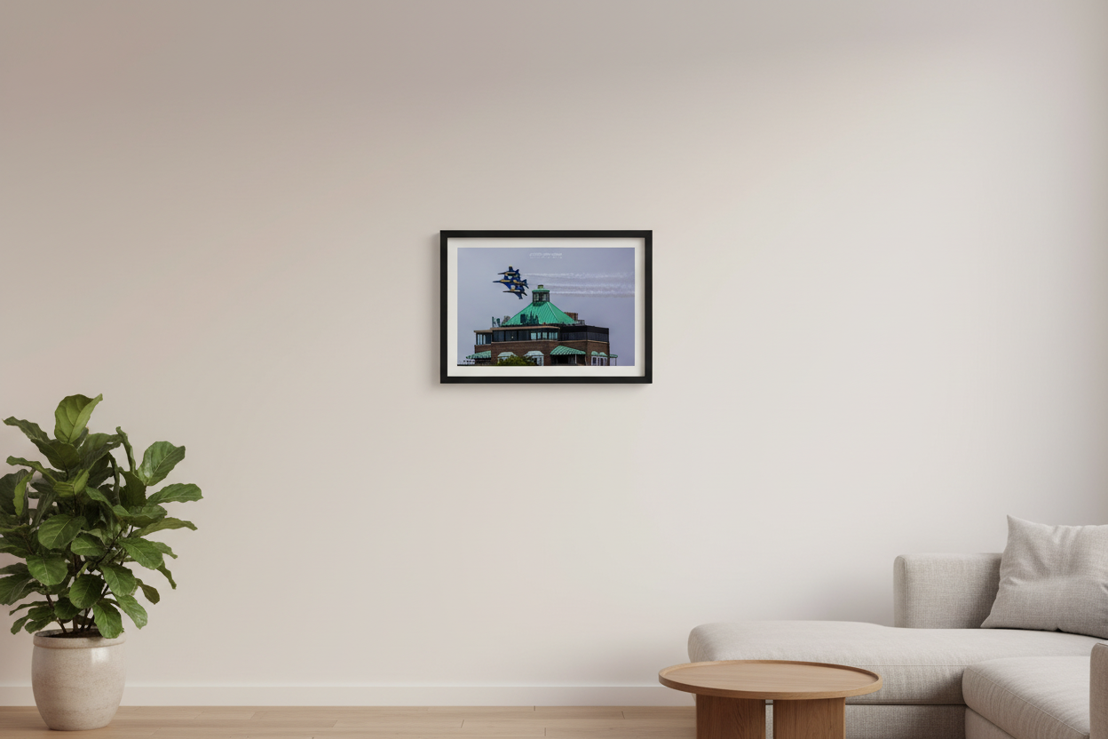 Small fine art landscape print of Blue Angels F/A-18 Hornets in tight diamond formation flying just above the green copper roof of the Park Place Hotel in Traverse City during the 2024 Cherry Festival Airshow displayed in modern living room