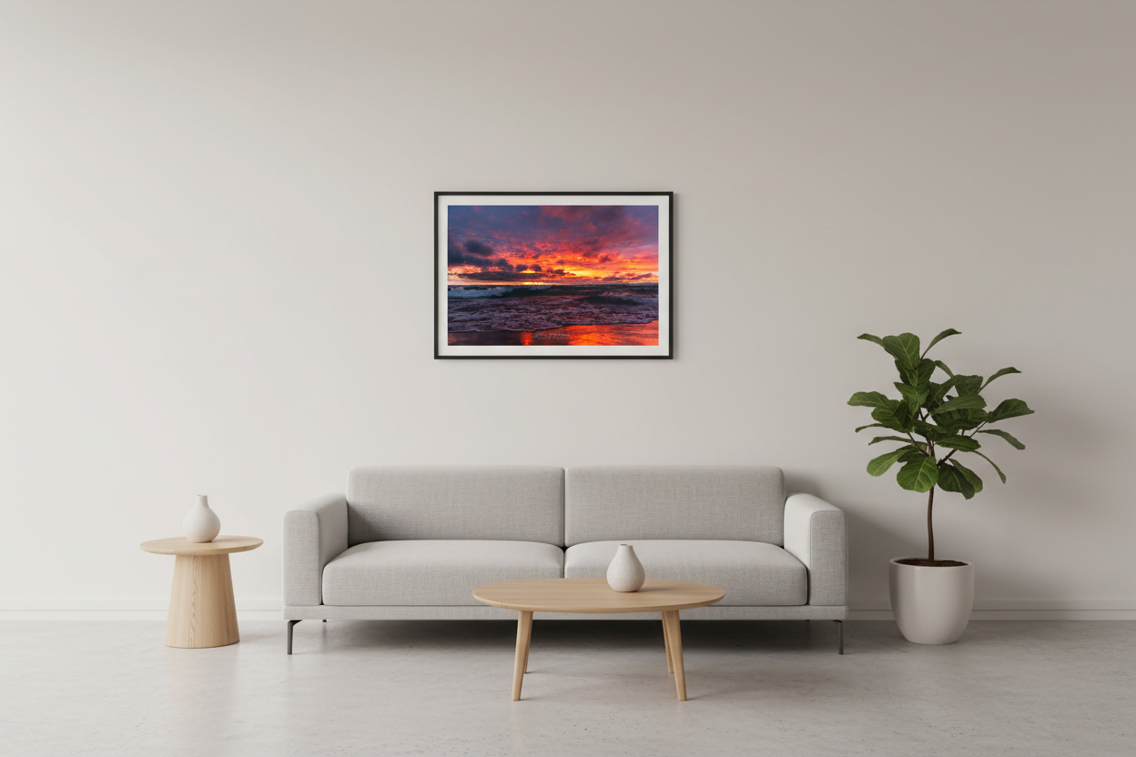 Small fine art landscape print of explosive magenta crimson gold lava sunset with dramatic storm clouds and crashing teal waves on Lake Michigan Leland June 2024 displayed in modern living room