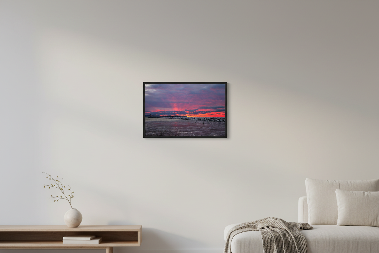 Small fine art landscape print of explosive fiery crimson and pink sunset with crepuscular rays over Pyramid Point and Sleeping Bear Bluffs from Fishtown Leland breakwall with icy water and polar plungers January 3 2022 displayed in modern living room