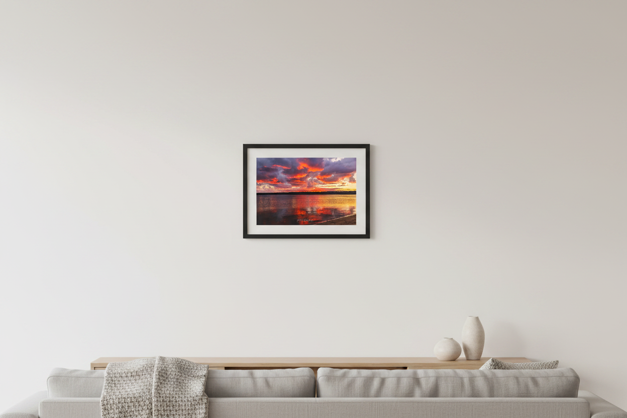 Small fine art landscape print of fiery crimson and purple fall sunrise with golden shoreline reflections over Lake Leelanau Michigan October 2023 displayed in modern living room