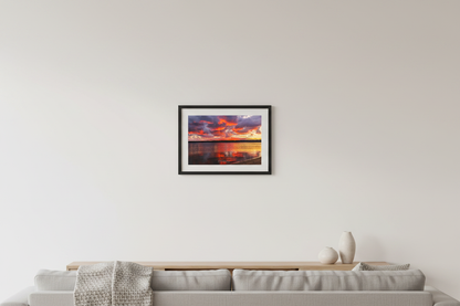 Small fine art landscape print of fiery crimson and purple fall sunrise with golden shoreline reflections over Lake Leelanau Michigan October 2023 displayed in modern living room