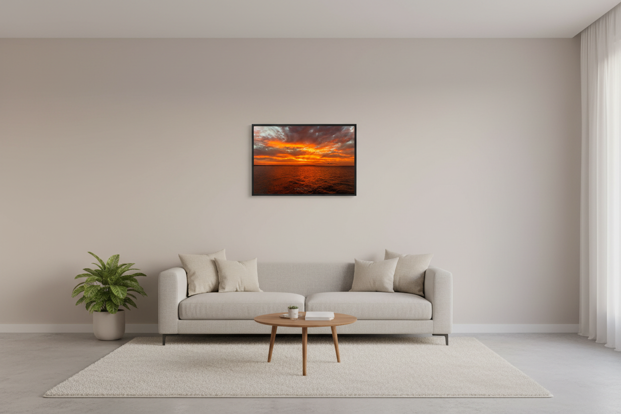 Small fine art print of blazing orange amber fire sunrise over open Grand Traverse Bay with towering dramatic storm cloud architecture and brilliant yellow white sun core displayed in modern living room