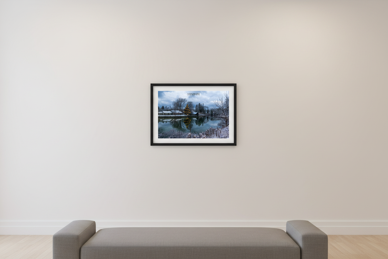 Small fine art print of illuminated Christmas tree reflected in the glassy Leland River with fresh snow on historic original dock wall and buildings in Leland Michigan December 11 2022 displayed in modern living room
