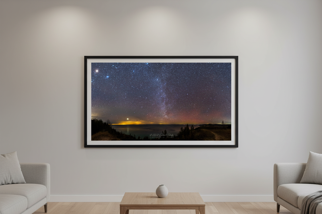 Large fine art 2:1 panorama print of Jupiter and the Winter Milky Way rising over Lake Michigan and the Manitou Islands with red aurora moon glow and silhouetted treeline from Port Oneida Overlook Sleeping Bear Dunes January 15 2023 displayed in modern living room