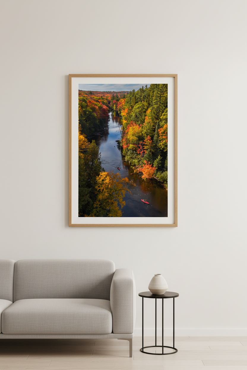 Large fine art portrait print of kayakers on the Dead River surrounded by peak fall foliage in Michigan's Upper Peninsula displayed in modern living room