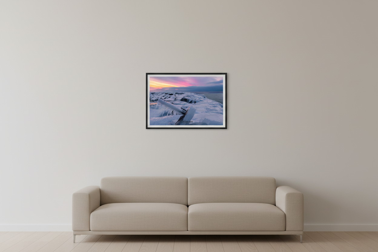 Small fine art landscape print of pink and magenta cotton candy afterglow sunset over ice-encrusted rocky breakwall with icicle foreground at Leland Michigan Lake Michigan February 18 2023 displayed in modern living room