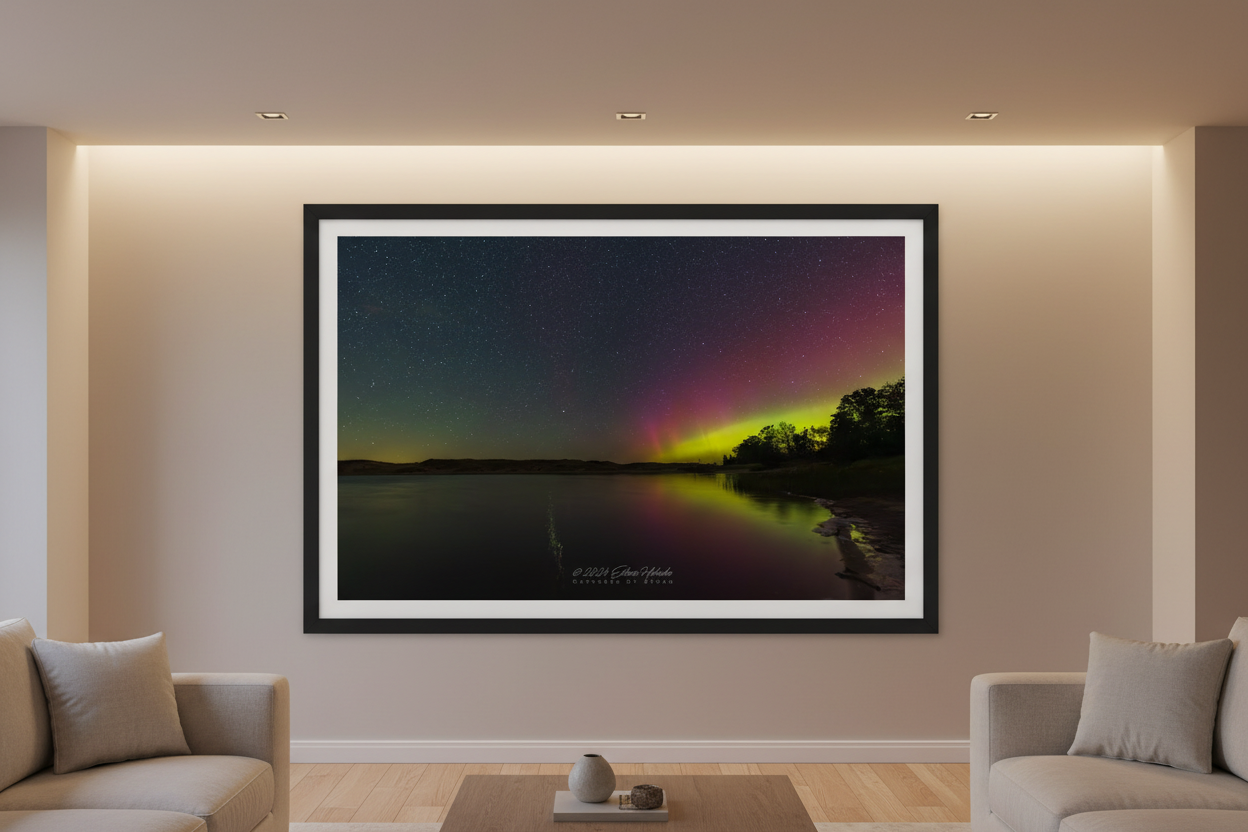 Large fine art print of crimson red and lime green Northern Lights aurora reflecting in glassy North Bar Lake with deciduous treeline silhouette and rolling hill horizon displayed in modern living room