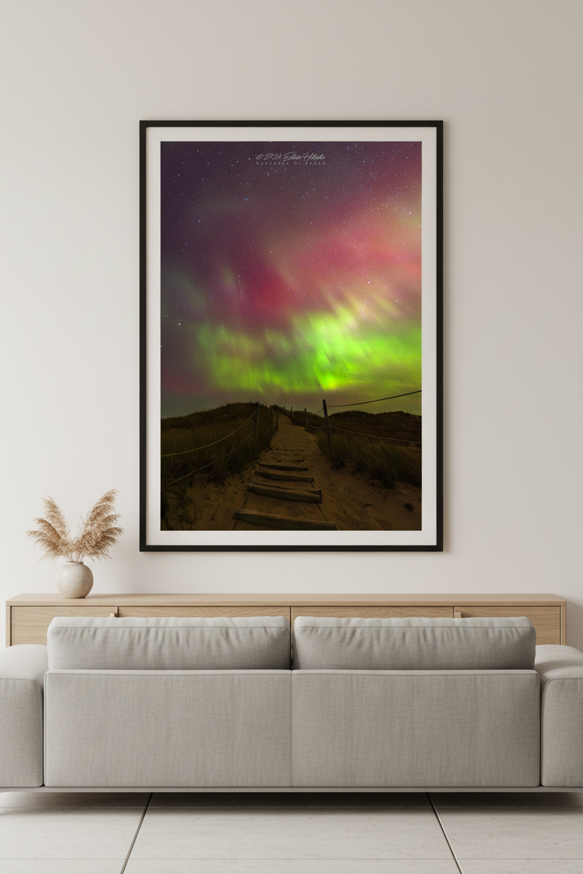 Large fine art portrait print of wooden boardwalk staircase with rope railings leading through sand dunes toward vivid green and crimson aurora display at North Bar Lake Michigan October 11 2024 at 1:33am displayed in modern living room