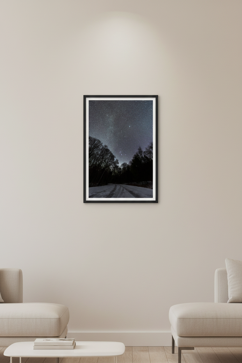 Small fine art portrait print of Comet C/2022 E3 ZTF and Orion constellation over snow-covered Pierce Stocking Drive road framed by bare winter trees at Sleeping Bear Dunes Michigan February 7 2023 displayed in modern living room