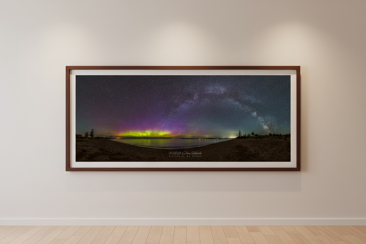Large fine art 3:1 panoramic print of Milky Way arch and northern lights aurora over Lake Michigan from Glen Haven Sleeping Bear Dunes Michigan May 2024 displayed in modern living room