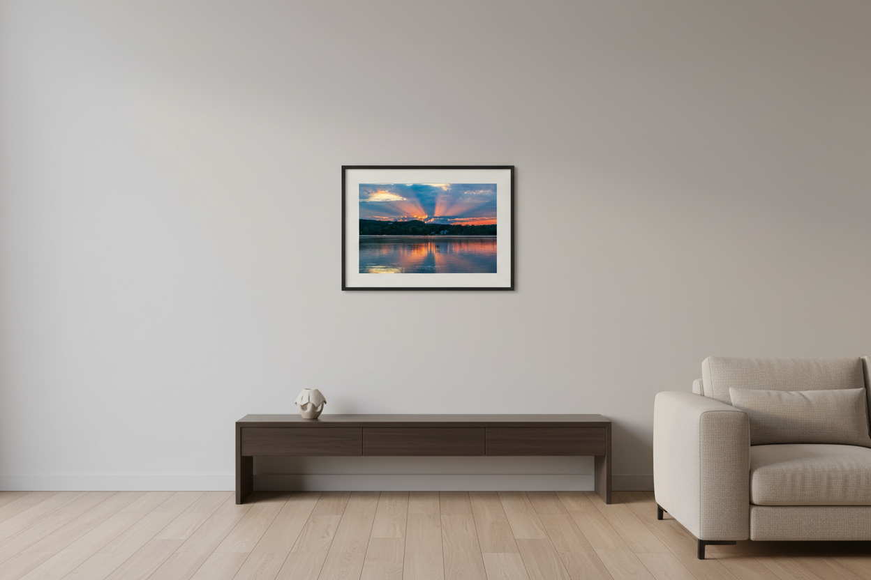 Small fine art landscape print of dramatic crepuscular rays bursting through storm clouds over glassy Lake Leelanau with warm orange horizon Michigan August 2022 displayed in modern living room