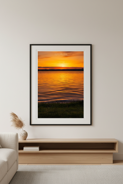 Large fine art portrait print of brilliant golden orange sunrise over calm Lake Leelanau Leland Michigan May 26 2024 displayed in modern living room