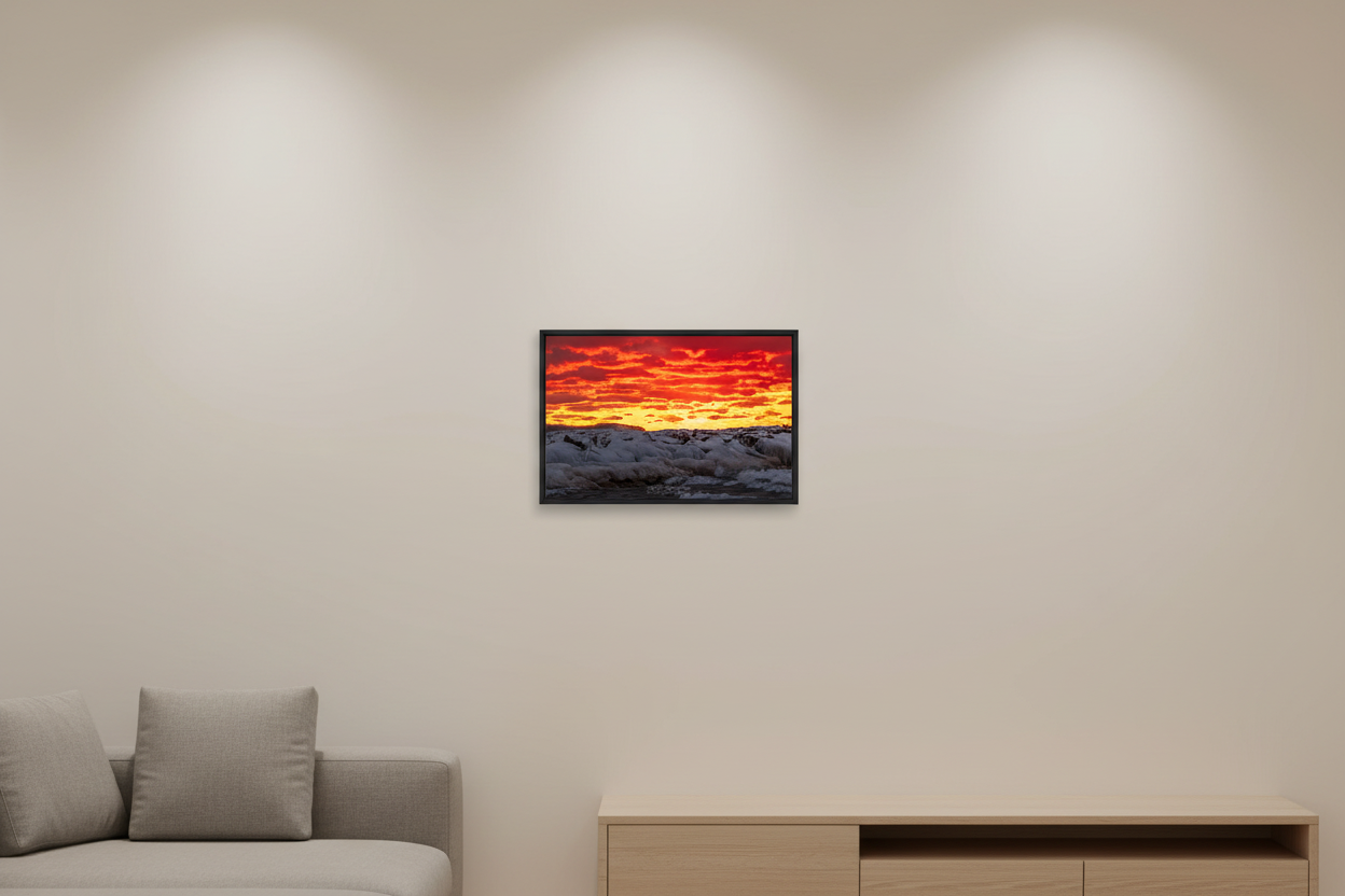 Small fine art landscape print of ice-encrusted Leland breakwall under a dramatic crimson and orange fire sunset sky with golden horizon glow Lake Michigan January 30 2023 displayed in modern living room