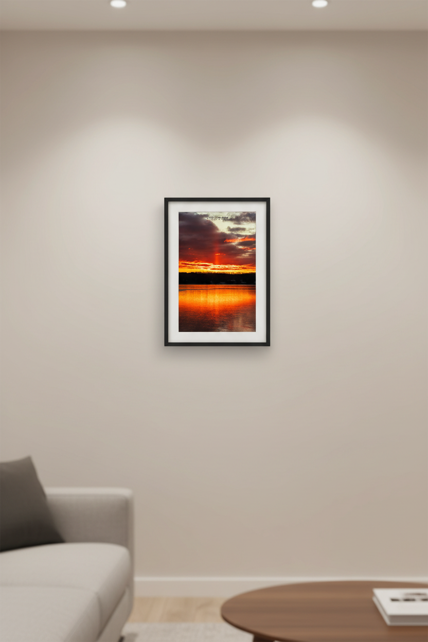 Small fine art portrait print of a sun pillar sunrise over Lake Leelanau Michigan with fiery red sky and water reflection displayed in modern living room