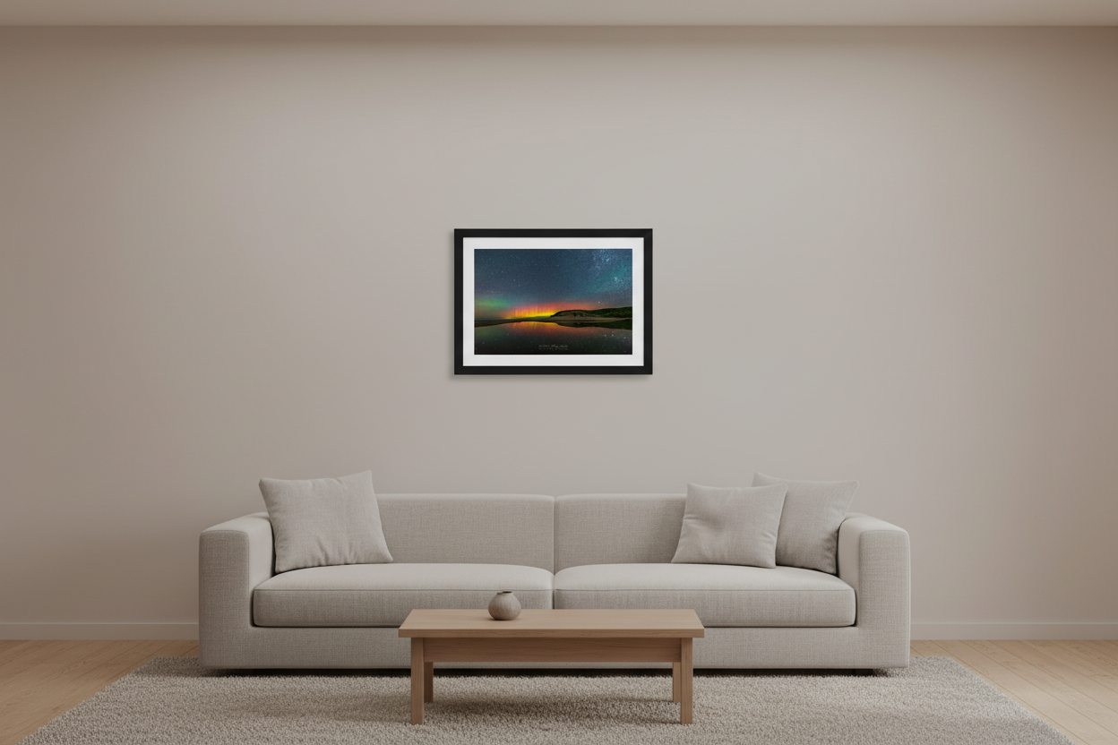 Small fine art landscape print of vivid red orange and yellow Northern Lights pillars perfectly mirrored in glassy North Bar Lake with sand dunes and forested bluff silhouetted on right and star-filled sky at Sleeping Bear Dunes Michigan August 31 2022 displayed in modern living room