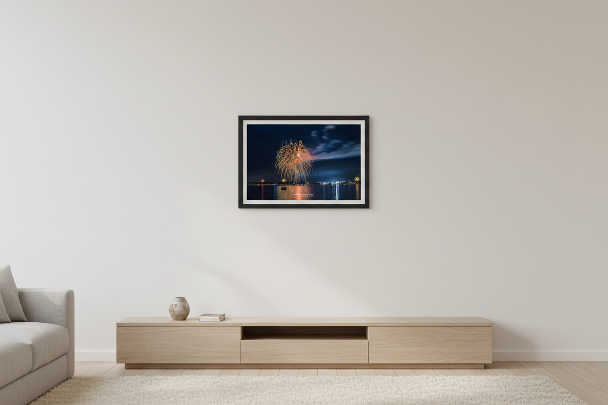 Small fine art landscape print of Traverse City 4th of July 2024 fireworks with golden multi-burst over Grand Traverse Bay and National Cherry Festival Ferris wheel glow displayed in modern living room