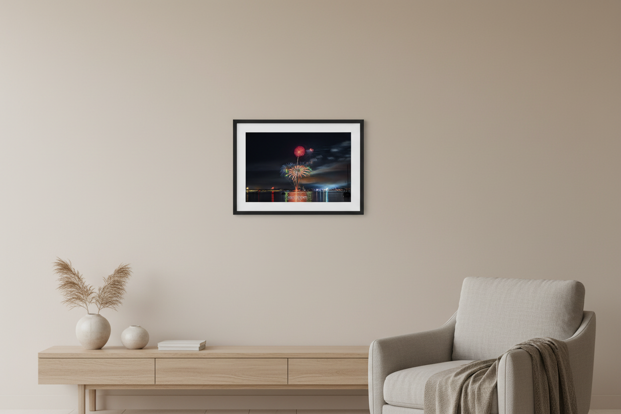 Small fine art landscape print of Traverse City 4th of July 2024 fireworks showing a red chrysanthemum atop a tall rocket trail with a wide golden palm burst below over Grand Traverse Bay with moody cloud-swept sky displayed in modern living room