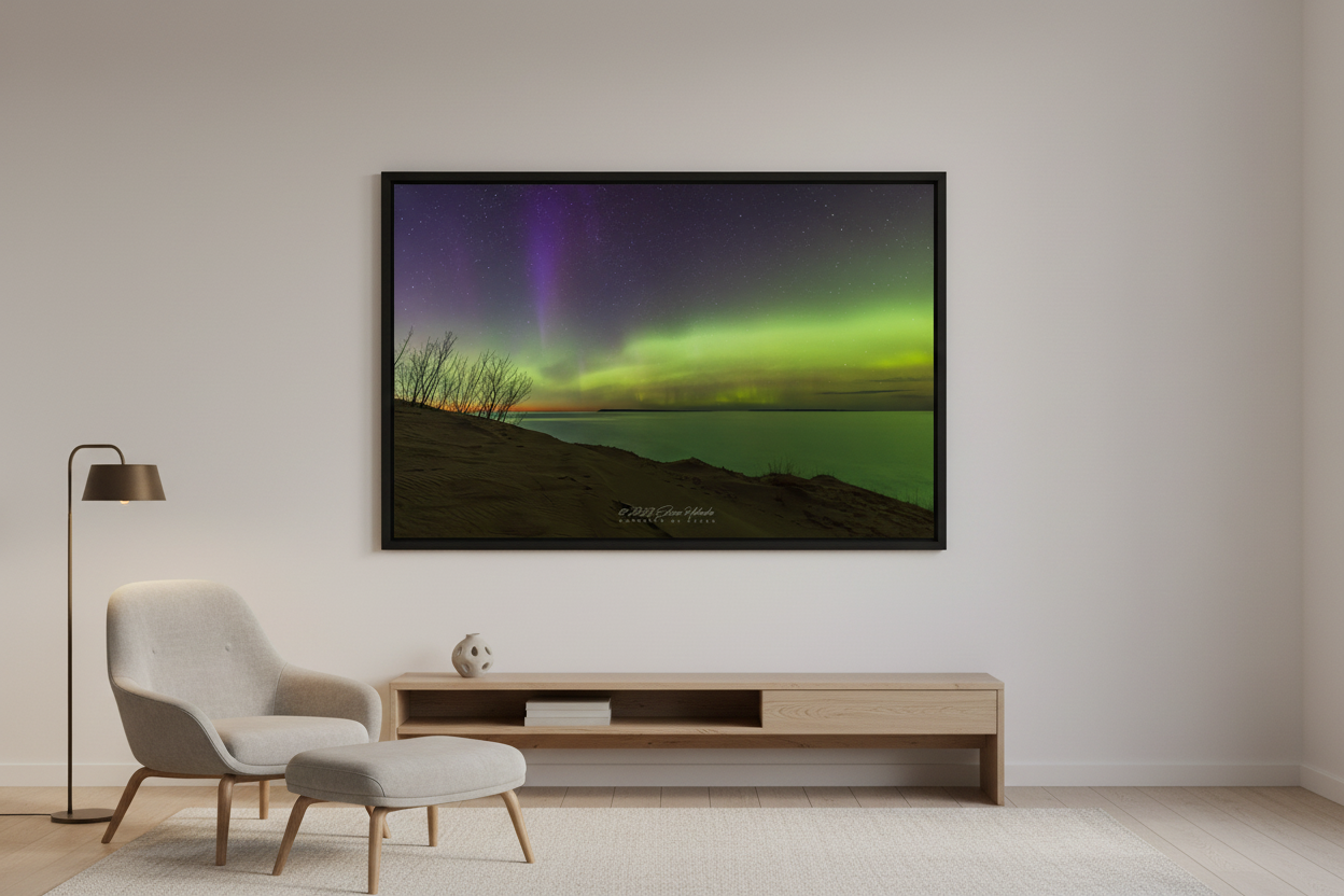 Large fine art landscape print of vivid green aurora band and purple violet pillars over Lake Michigan from Sleeping Bear Dunes overlook with sandy dunes and silhouetted trees March 23 2023 displayed in modern living room
