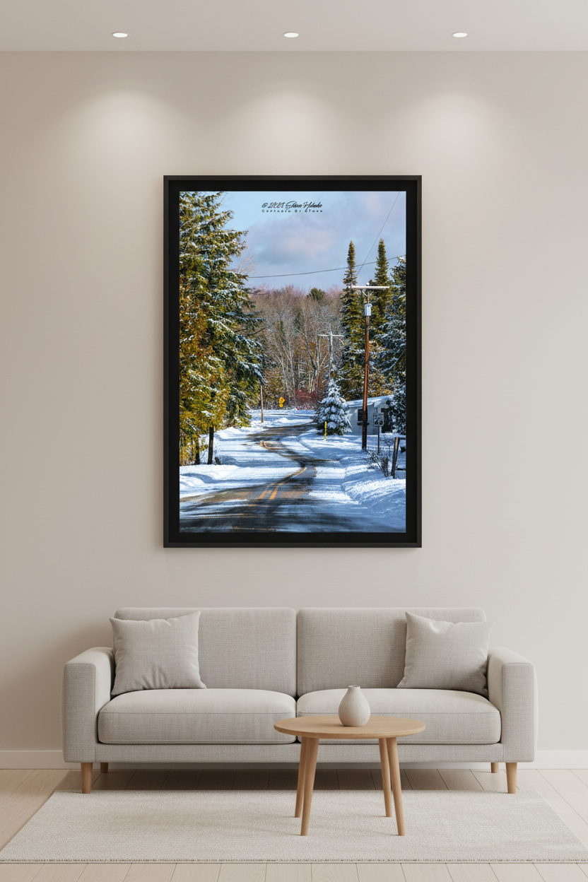Large fine art portrait print of snow-covered winding Leelanau County road lined with snow-laden evergreen trees and bare winter forest on a cloudy winter day February 28 2023 displayed in modern living room