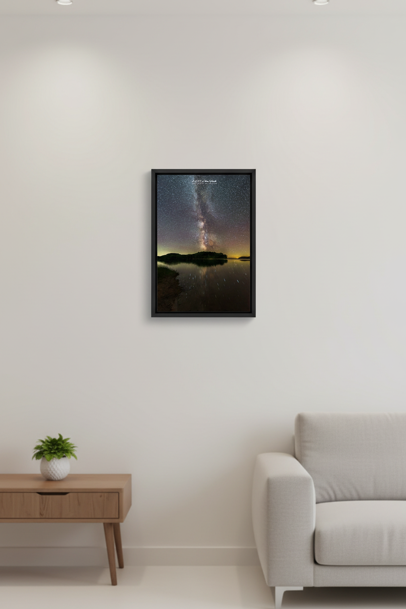 Small fine art portrait print of Milky Way galactic core rising vertically over dark silhouetted island with trees reflecting in perfectly still water with diagonal star trails at North Bar Lake Sleeping Bear Dunes Michigan August 31 2022 displayed in modern living room