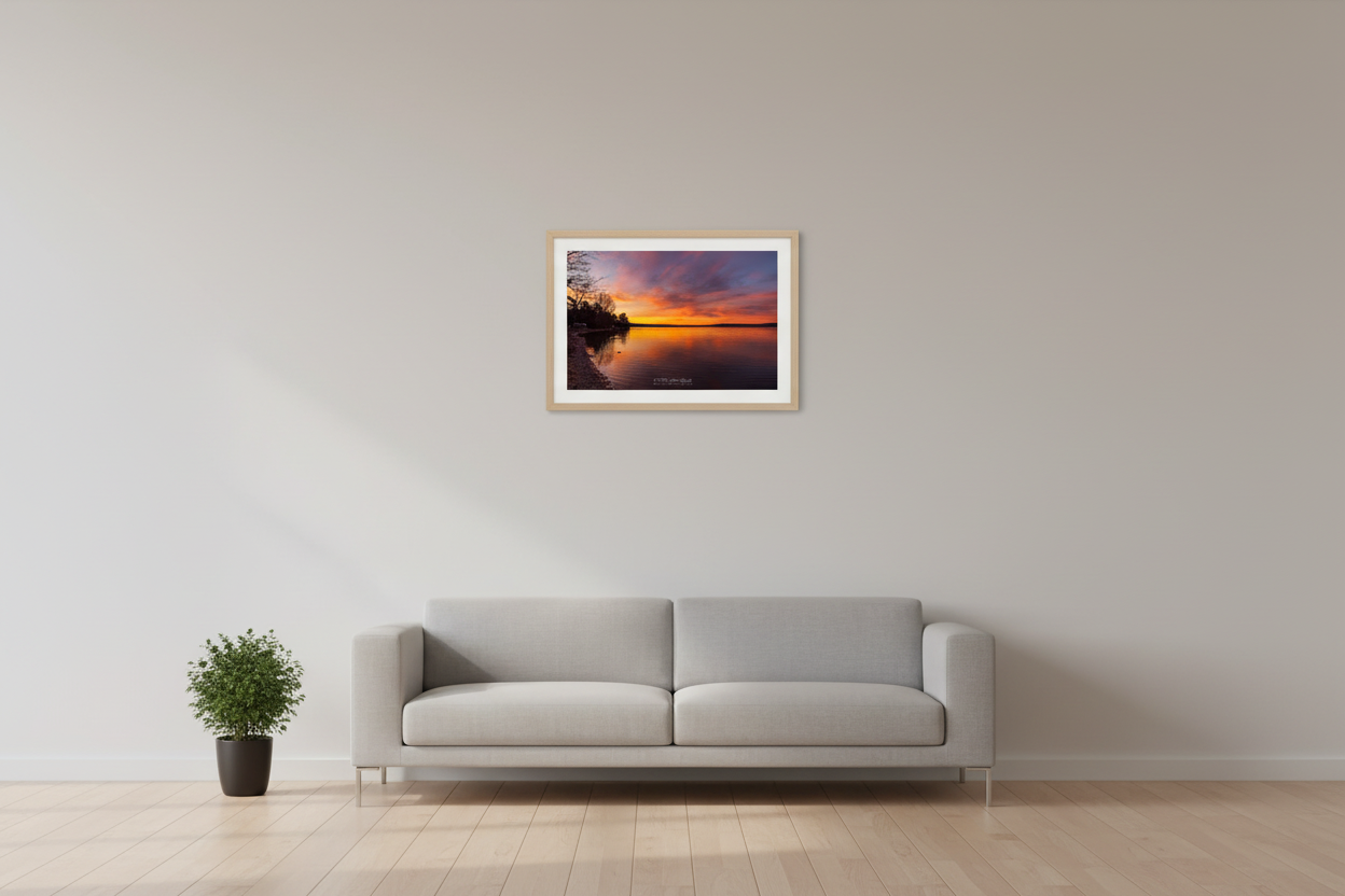Small fine art landscape print of serene golden sunrise over Lake Leelanau with winter tree silhouettes Leelanau County Michigan displayed in modern living room
