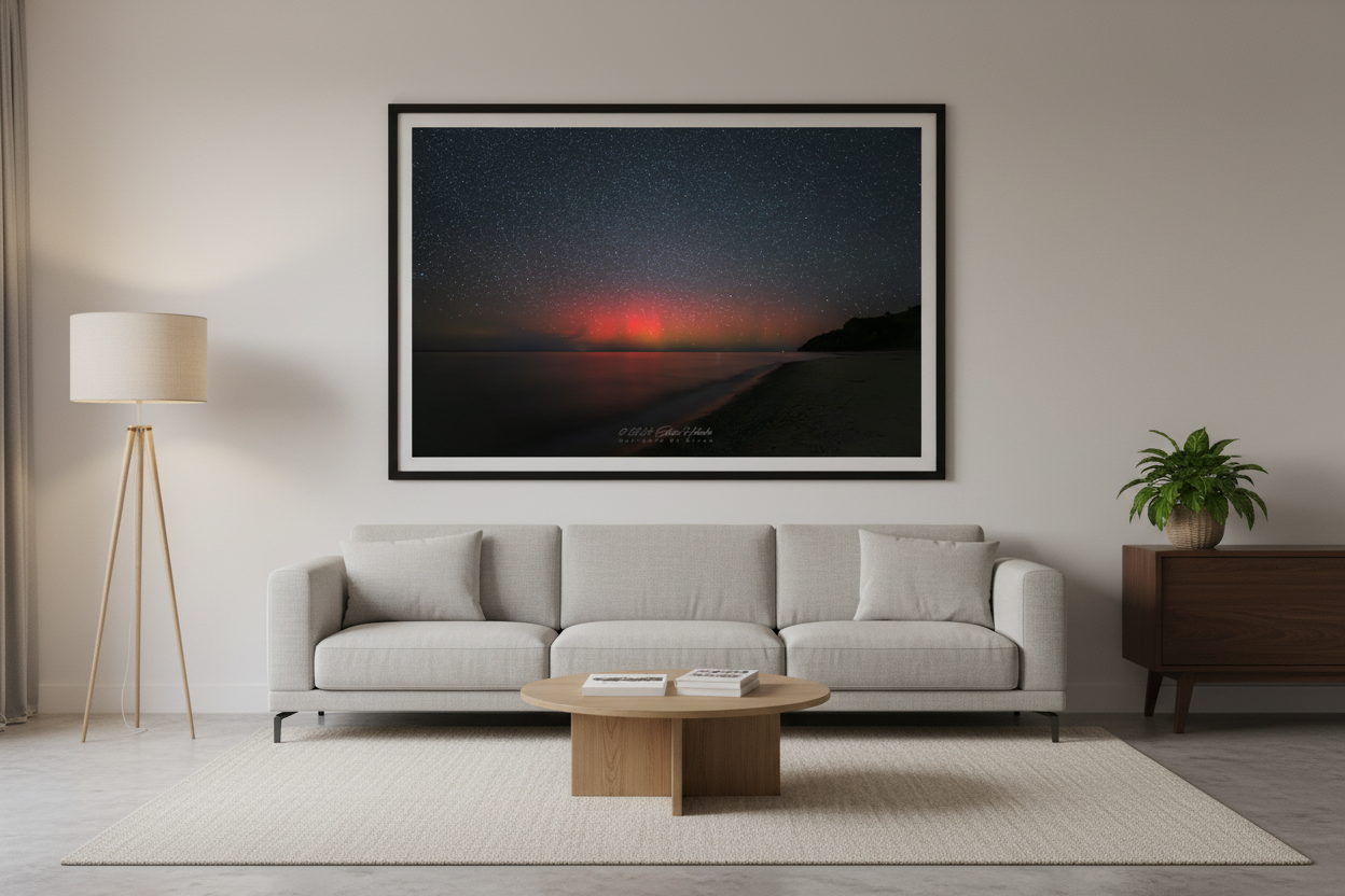 Large fine art print of intense crimson red aurora borealis pillars over Lake Michigan from North Street Beach Leland Michigan dark headland silhouette lower right smooth sandy beach long exposure calm water Oct 5 2024 3:08am displayed in modern living room