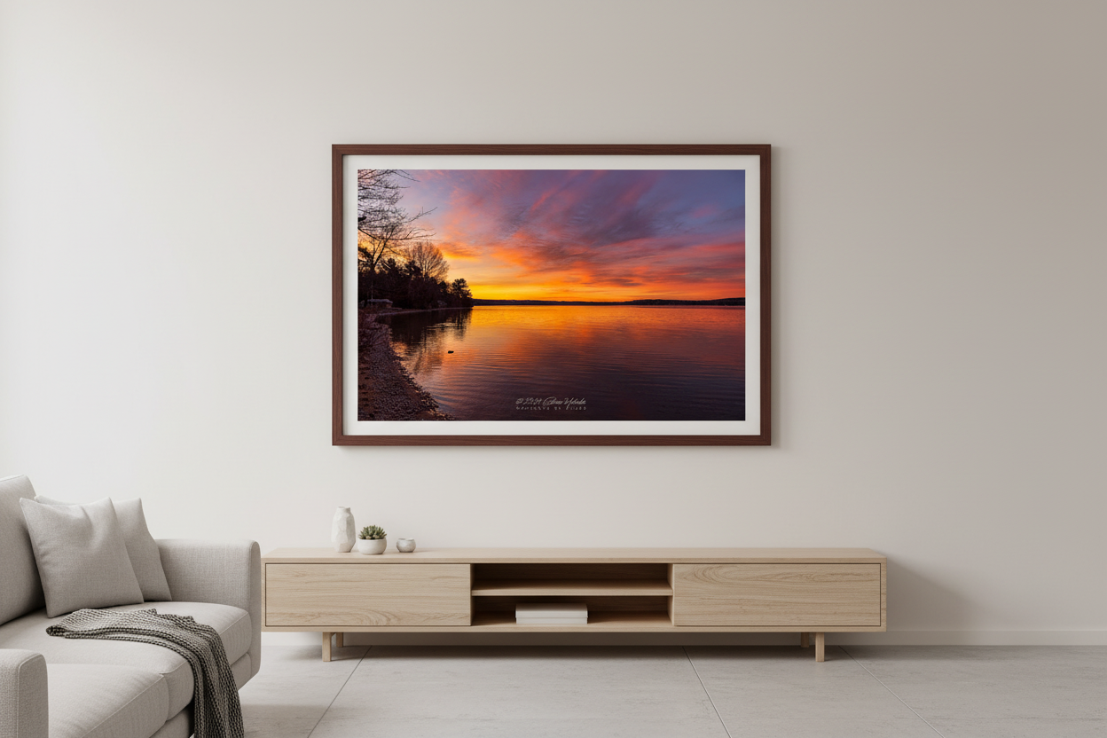 Large fine art landscape print of serene golden sunrise over Lake Leelanau with winter tree silhouettes Leelanau County Michigan displayed in modern living room