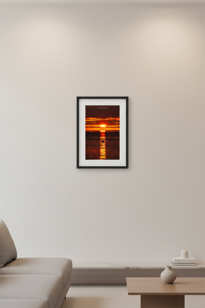 Small fine art portrait print of swan silhouette centered in golden reflection path beneath deep crimson orange layered sky at Gills Pier Lake Michigan May 2024 displayed in modern living room