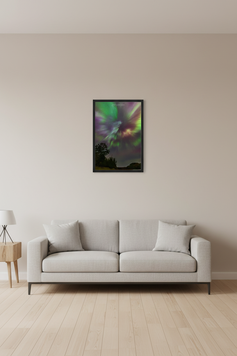 Small fine art portrait print of rare aurora corona event with explosive radial rays of green yellow crimson red purple and white bursting from central point over silhouetted tree line at North Bar Lake Michigan October 11 2024 at 1:10am displayed in modern living room