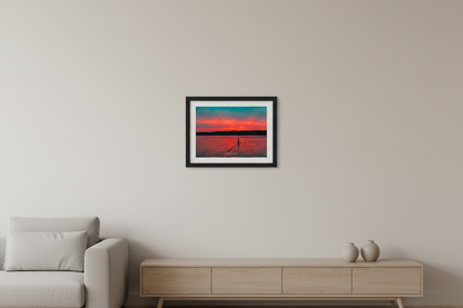Small fine art print of Lake Leelanau fire sunset afterglow with single wooden swim rope post V-shaped buoy lines vivid saturated teal sky sweeping crimson orange cloud band golden afterglow at treeline vast open water foreground no dock Leland Michigan displayed in modern living room
