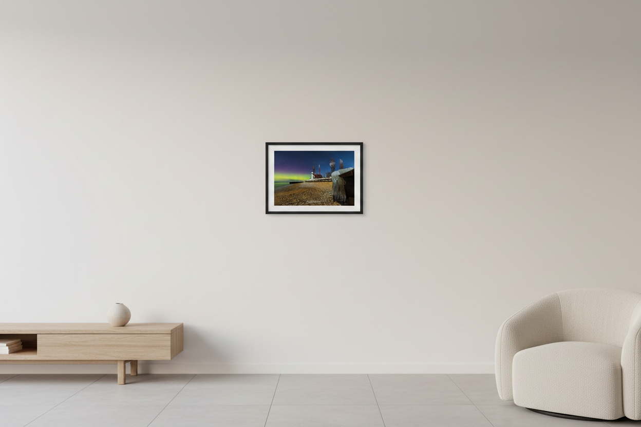 Small fine art landscape print of vivid green and magenta aurora borealis over Point Betsie Lighthouse on a snowy winter night with rocky beach ice formations and wooden pier Lake Michigan Michigan February 26 2023 displayed in modern living room