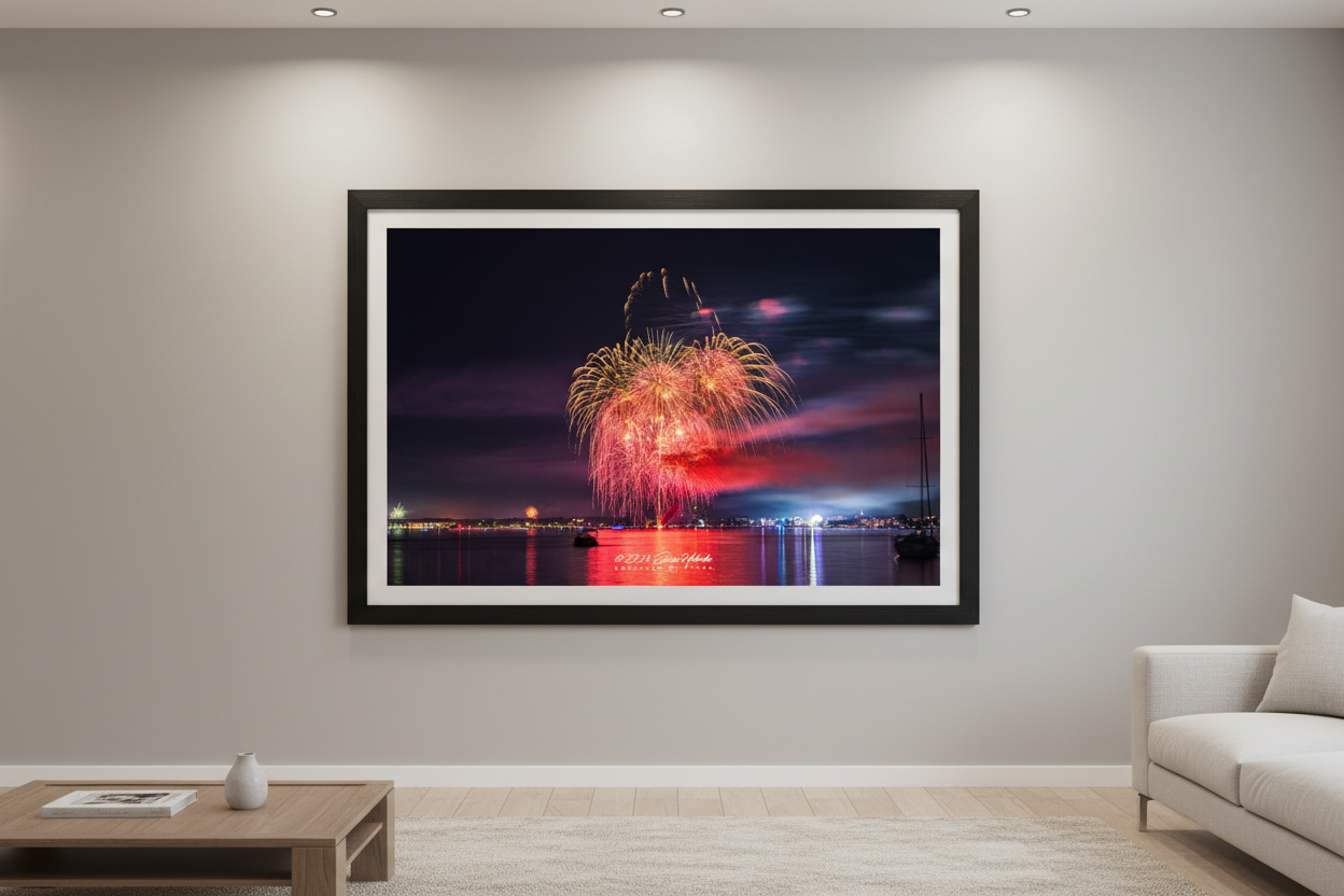 Large fine art landscape print of Traverse City 4th of July 2024 fireworks showing a lush multi-layered gold and pink peony cluster with wild smoke trails above a pink-purple glowing sky over Grand Traverse Bay displayed in modern living room