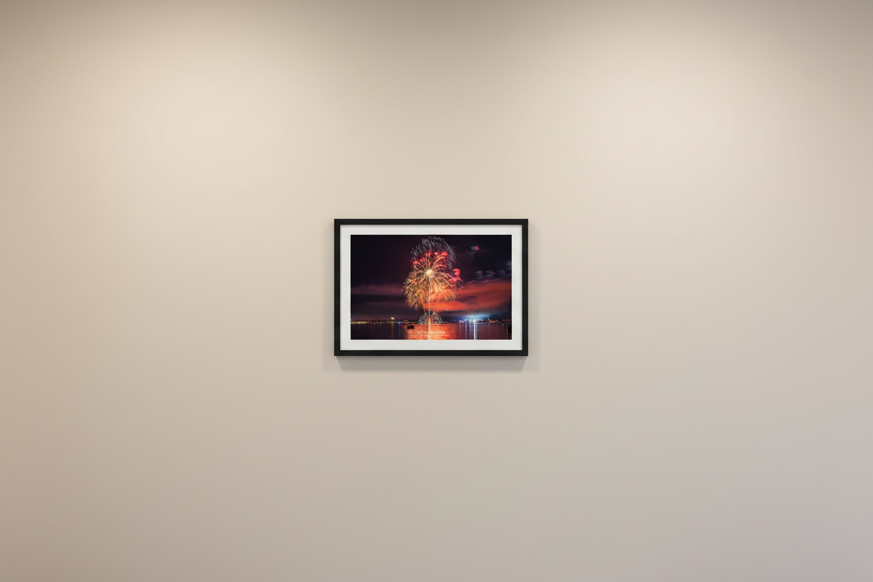 Small fine art landscape print of Traverse City 4th of July 2024 fireworks showing a dramatic crimson sky with vertical rocket trail, golden peony burst, and symmetrical white glitter crown arc over Grand Traverse Bay displayed in modern living room