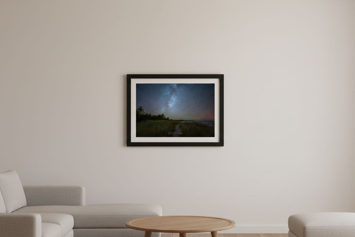 Small fine art print of Milky Way galaxy over Bohemian Road Beach Michigan with aurora borealis pink red glow on horizon sandy beach path tall beach grass pine tree silhouettes calm water Oct 5 2024 displayed in modern living room