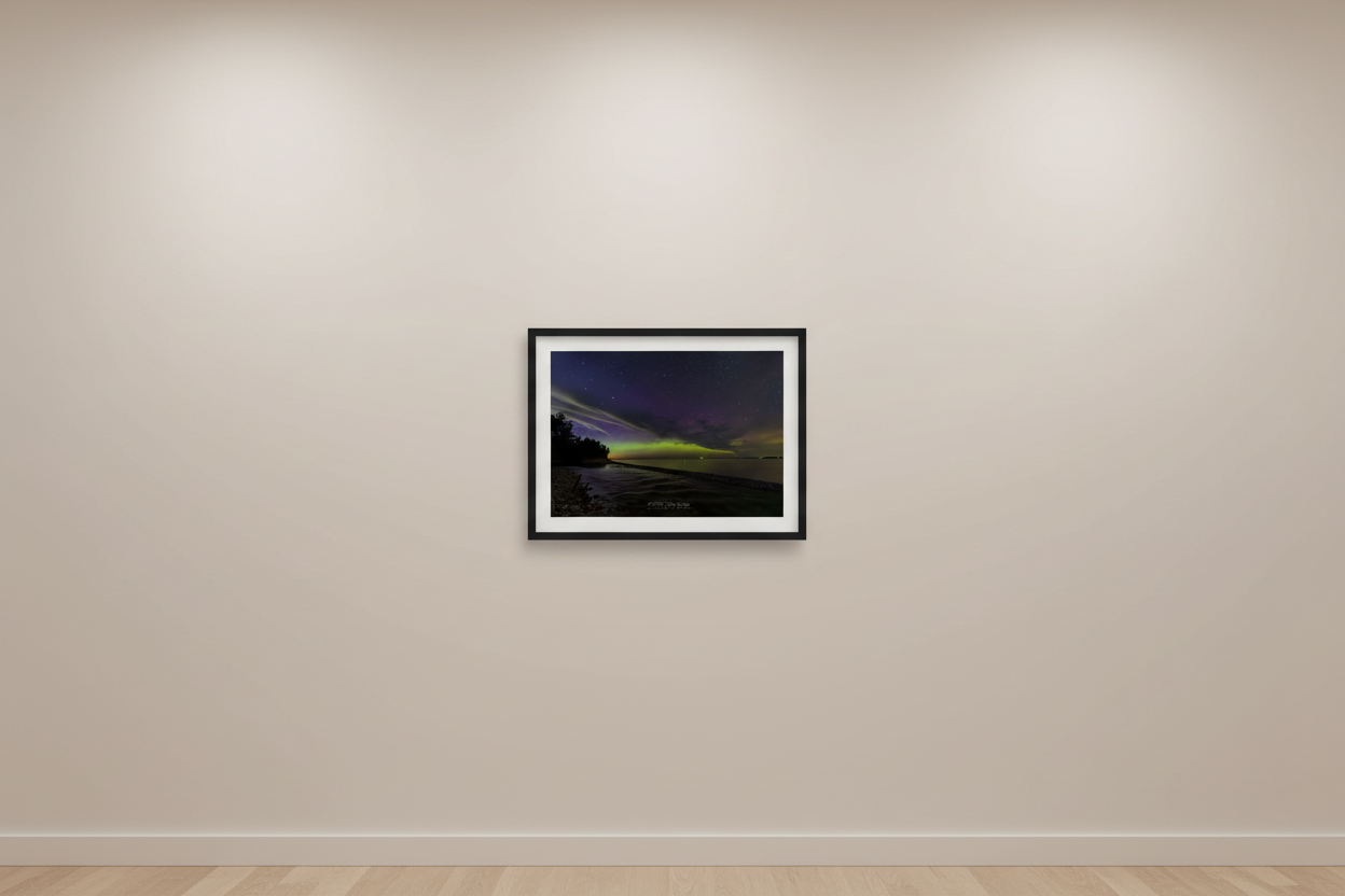 Small fine art print of lime green and purple magenta Northern Lights aurora over Shalda Creek rocky shoreline with pine tree silhouette at Sleeping Bear Dunes MI displayed in modern living room