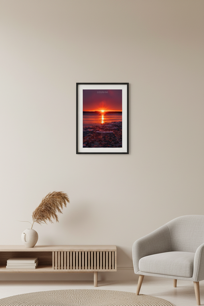 Small fine art portrait print of blazing crimson sunrise with glowing pancake ice floes on Good Harbor Bay Michigan February 2023 displayed in modern living room