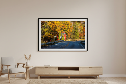 Large fine art landscape print of the Little Red Schoolhouse on M-22 surrounded by fall color Michigan displayed in modern living room