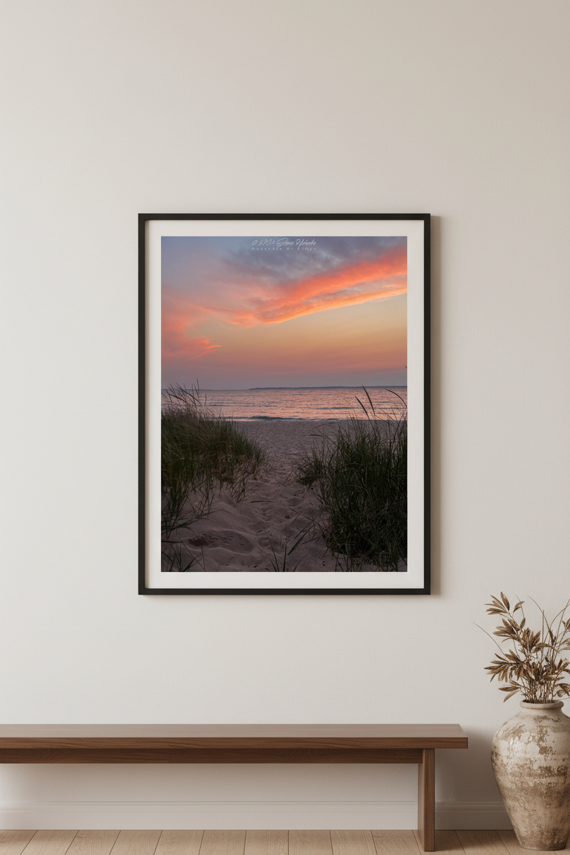Large fine art portrait print of coral orange and pink sunset over Lake Michigan beach path framed by dune grass at Van's Beach Leland Michigan May 13 2024 displayed in modern living room