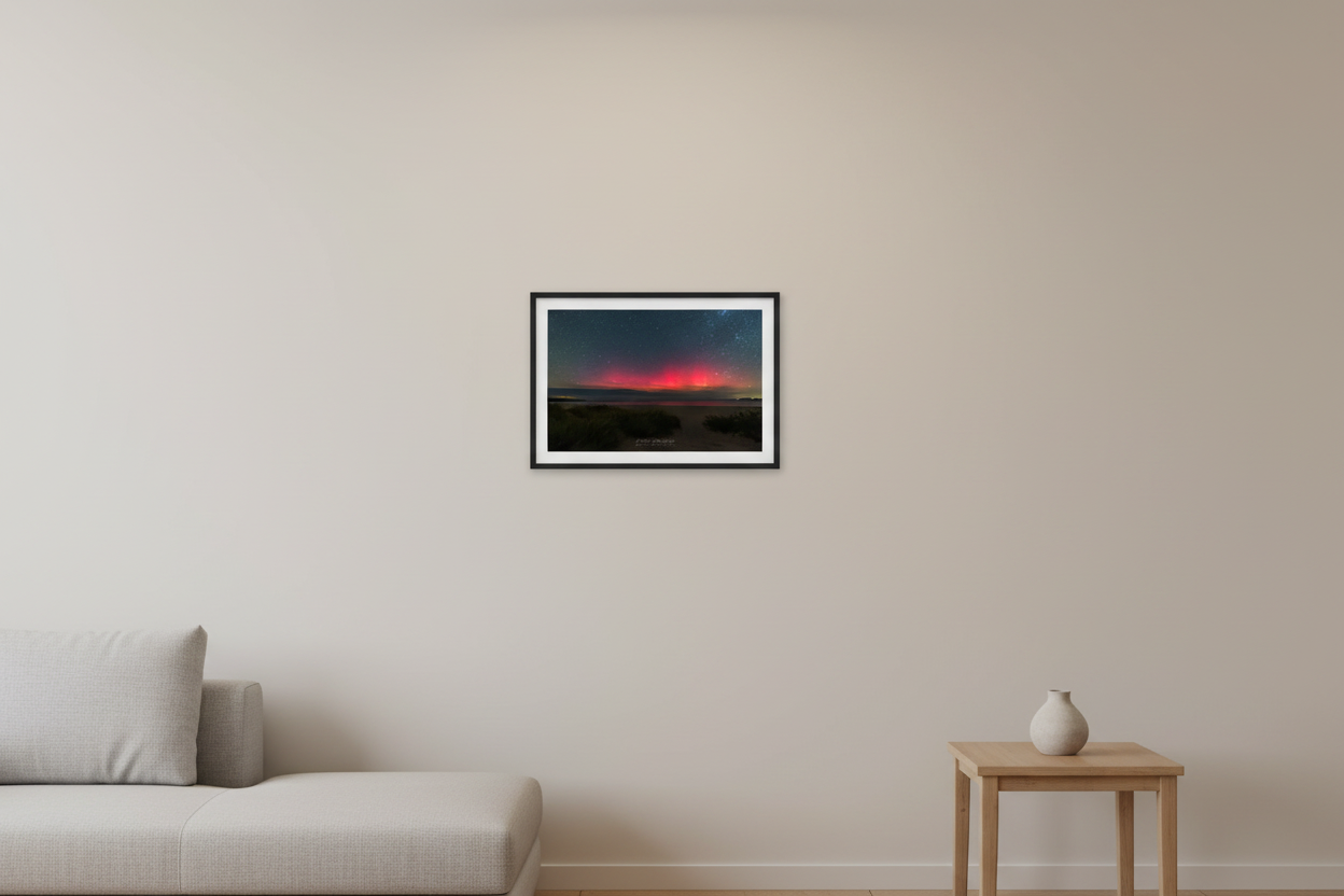 Small fine art print of pure deep crimson red aurora above cloud bank over Lake Michigan from Bohemian Road Beach with sandy dune beach path and dune grass foreground deep teal starfield Sleeping Bear Dunes displayed in modern living room