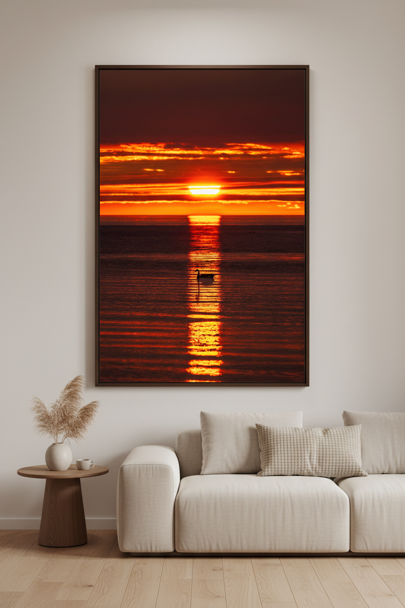 Large fine art portrait print of swan silhouette centered in golden reflection path beneath deep crimson orange layered sky at Gills Pier Lake Michigan May 2024 displayed in modern living room