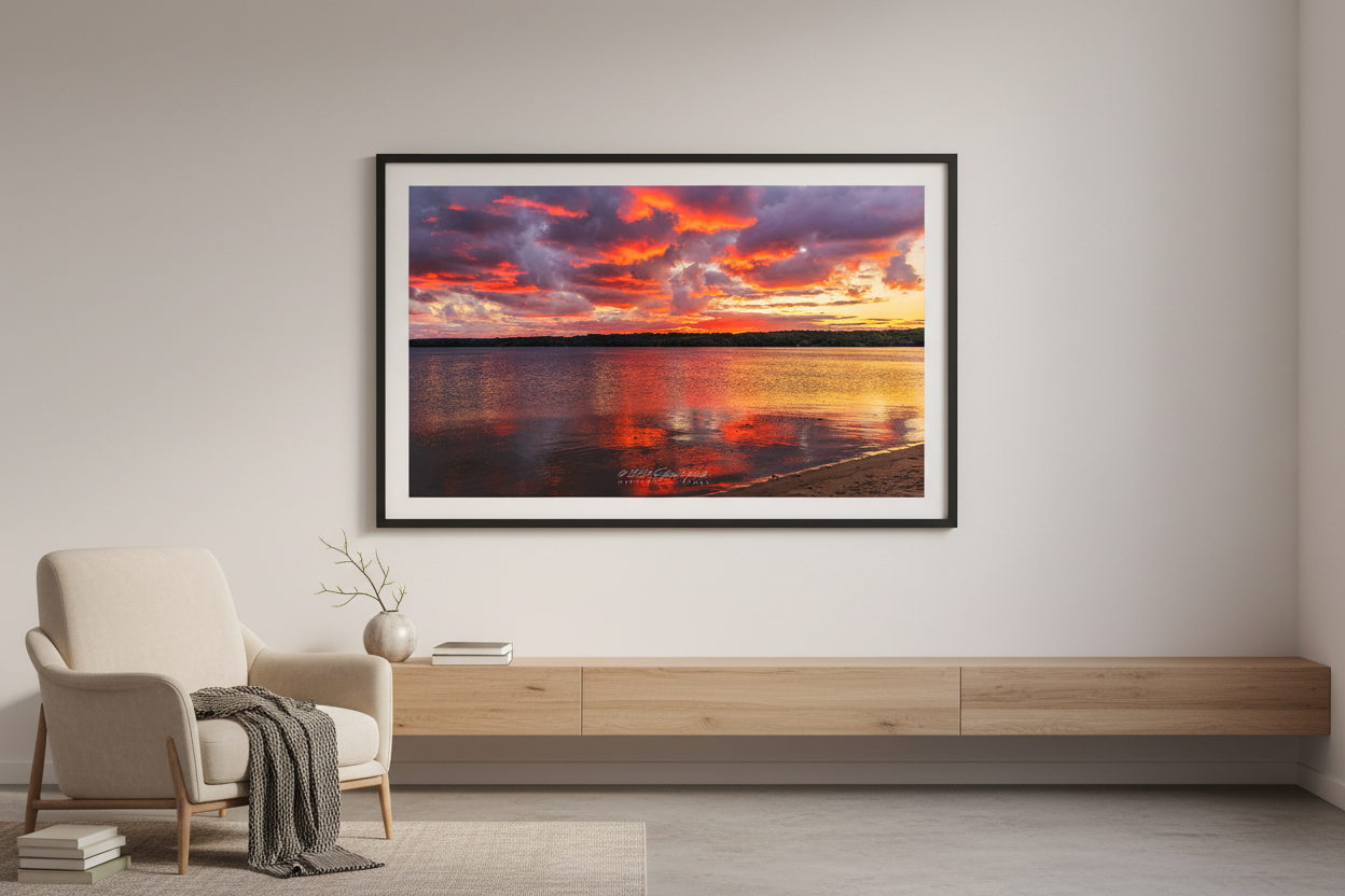 Large fine art landscape print of fiery crimson and purple fall sunrise with golden shoreline reflections over Lake Leelanau Michigan October 2023 displayed in modern living room