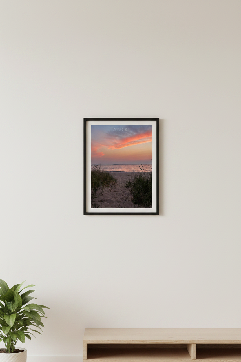 Small fine art portrait print of coral orange and pink sunset over Lake Michigan beach path framed by dune grass at Van's Beach Leland Michigan May 13 2024 displayed in modern living room