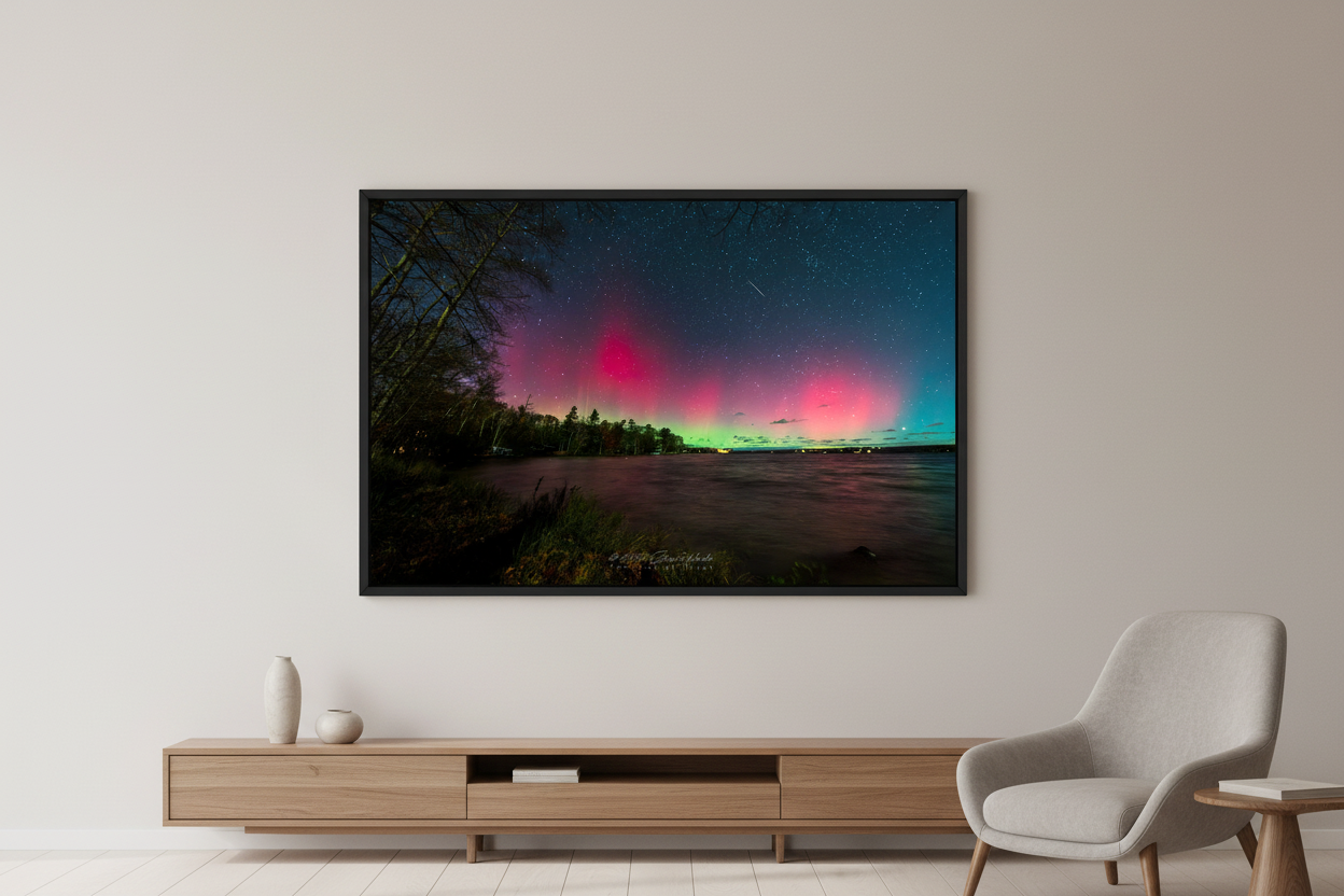 Large fine art print of split dual aurora structures with crimson left column and soft pink right glow over Lake Leelanau from Leland Michigan November 8 2024 8:33pm with meteor streak and water reflection displayed in modern living room