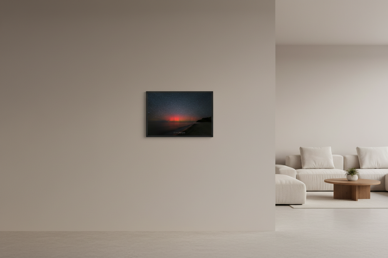 Small fine art print of intense crimson red aurora borealis pillars over Lake Michigan from North Street Beach Leland Michigan dark headland silhouette lower right smooth sandy beach long exposure calm water Oct 5 2024 3:08am displayed in modern living room