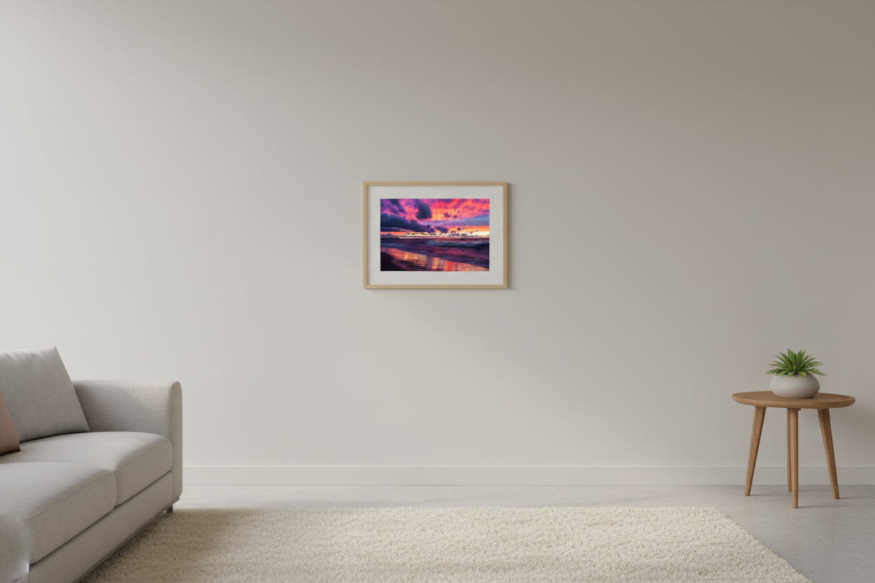 Small fine art landscape print of vivid magenta violet gold sunset with dramatic storm clouds and glowing wave reflections on Lake Michigan beach Leland Michigan September 2021 displayed in modern living room