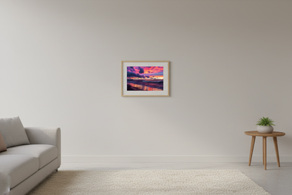 Small fine art landscape print of vivid magenta violet gold sunset with dramatic storm clouds and glowing wave reflections on Lake Michigan beach Leland Michigan September 2021 displayed in modern living room