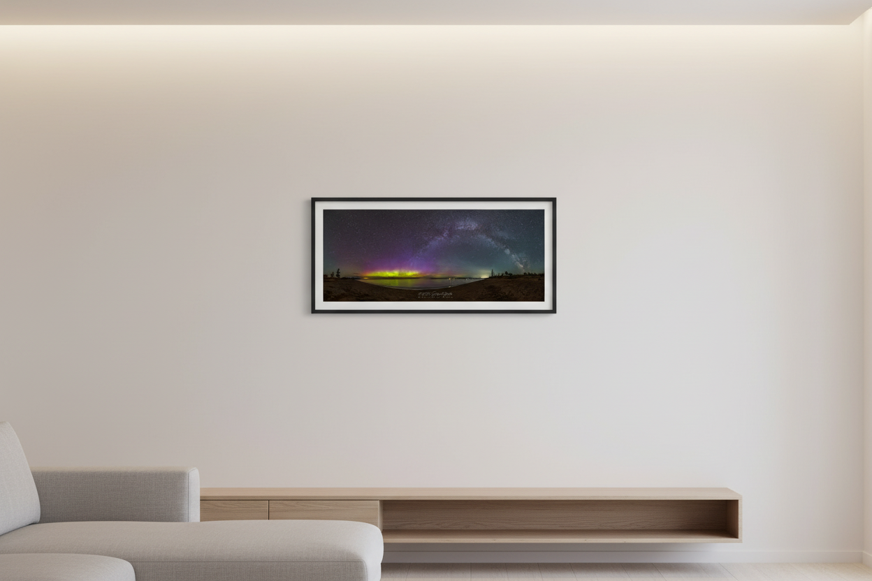 Small fine art 3:1 panoramic print of Milky Way arch and northern lights aurora over Lake Michigan from Glen Haven Sleeping Bear Dunes Michigan May 2024 displayed in modern living room