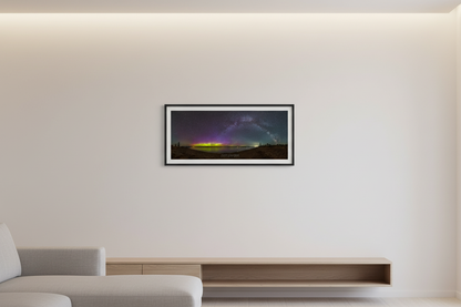 Small fine art 3:1 panoramic print of Milky Way arch and northern lights aurora over Lake Michigan from Glen Haven Sleeping Bear Dunes Michigan May 2024 displayed in modern living room