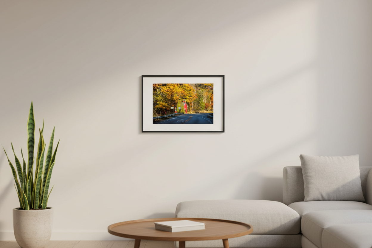 Small fine art landscape print of the Little Red Schoolhouse on M-22 surrounded by fall color Michigan displayed in modern living room